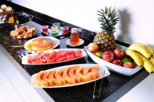 a table with plates of fruit on a counter at Grande Hotel Araçatuba in Araçatuba