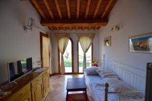 ein Wohnzimmer mit einem Sofa und einem TV in der Unterkunft CASE&COLLINE Villa Lorena in Montescudaio