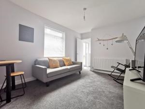 ein Wohnzimmer mit einem Sofa und einem Tisch in der Unterkunft Richmond Apartments by Switchback Stays in Cardiff