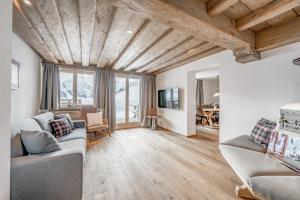 a living room with two couches and a wooden ceiling at Bühlhof Appartements in Lech am Arlberg