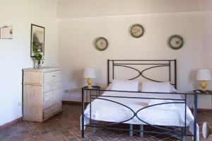 Un dormitorio con una cama y dos lámparas y una cómoda. en Tenuta San Calogero Appartamento Alloro, en Agnone Bagni 28 fotos más