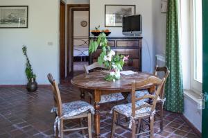 uma sala de jantar com uma mesa de madeira e cadeiras em Tenuta San Calogero Appartamento Alloro em Agnone Bagni