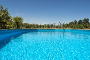 a pool of blue water with trees in the background at Tenuta San Calogero App Rosmarino in Agnone Bagni