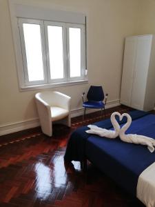 Dos toallas de cisne en una cama en una habitación en Blue Bairro Guesthouse, en Lisboa