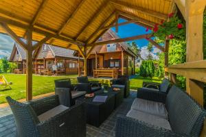 an outdoor patio with wicker chairs and tables at Domki Letniskowe in Sztutowo