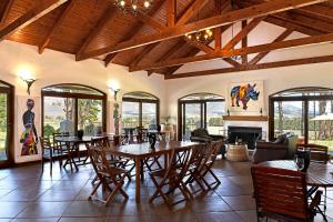 a dining room with tables and chairs and a fireplace at Topiary Wine Estate & Cottages in Franschhoek