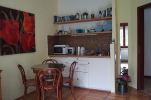 cocina con mesa, sillas y microondas en Ria's Apartment en Budapest