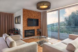 a living room with two couches and a fireplace at Prestige Sea View Villa in Gaula