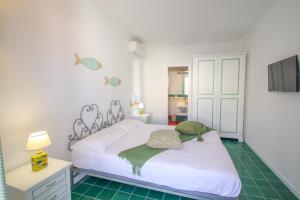a bedroom with a white bed and a television at Casa Pesce in Ponza