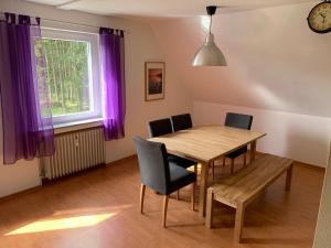 a dining room with a table and chairs and a window at Heidewohnung in Soltau