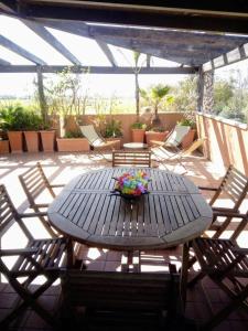 - une table avec un bol de fleurs sur la terrasse dans l'établissement Grazioso appartamento al mare, in prov. di Matera, à Marina di Pisticci