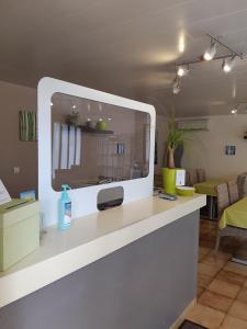 a white counter with a large tv on top of it at Hotel Les Pins in Hourtin