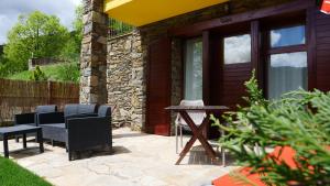 un patio con sillas y una mesa frente a una casa en Apartaments Fontalba, en Queralbs