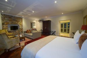 a bedroom with a large bed and a living room at Parkwood Boutique Hotel in Johannesburg