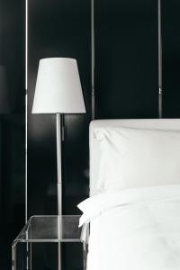 a table with a lamp next to a bed at 101 Hotel, a Member of Design Hotels in Reykjavík