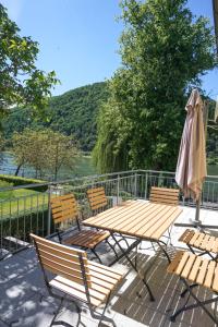 a wooden table and chairs with a table and an umbrella at Rheinterrasse Wohnung 1 in Lahnstein
