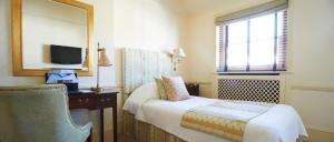 a bedroom with a bed and a mirror and a television at Durrants Hotel in London +99 photos