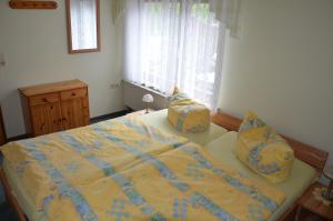 a bedroom with a bed with yellow sheets and pillows at Ferienwohnung Richter in Bad Schandau