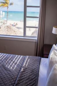 A bed or beds in a room at Riptide Oceanfront Hotel