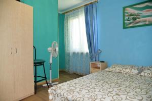 a bedroom with a bed and a desk and a window at Domik na Fontane in Odesa