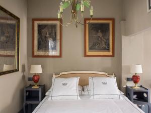 1 dormitorio con 1 cama con 2 lámparas y 2 fotografías en VAC LUXURY HOME SEVILLA, en Sevilla