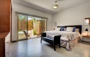 1 dormitorio con 1 cama y puerta corredera de cristal en Poolside Bliss Luxury, Private Terrace with Jacuzzi en Tulum