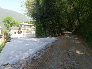 a road with a fence and a gate and trees at B&B Al Sentiero in Caprino Veronese