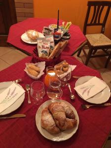 einen Tisch mit Teller mit Lebensmitteln auf einem roten Tischtuch in der Unterkunft Le Chalet del Pollino in Rotonda