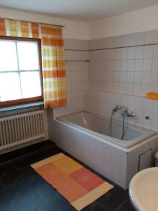 ein Badezimmer mit einer Badewanne und einem Waschbecken in der Unterkunft Schneiderhof in Steinbach
