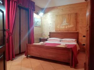 1 dormitorio con 1 cama grande y cortinas rojas en Le Chalet del Pollino, en Rotonda