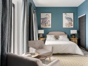 a bedroom with blue walls and a bed and a chair at VAC LUXURY HOME SEVILLA in Seville