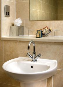 y baño con lavabo y espejo. en Grovefield House Hotel en Slough