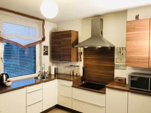 a kitchen with white cabinets and a stove at Haus Graf Velden in Velden am Wörthersee