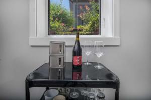 a glass table with a bottle of wine and two glasses at Southeast Portland Retreat in Portland