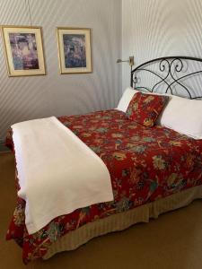 a bedroom with a bed with a red blanket at Hotel St Nicholas in Cripple Creek