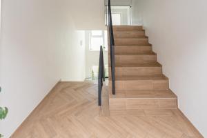 eine Treppe in einem Haus mit Holzböden in der Unterkunft Apartament Malūno in Palanga