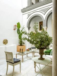 una habitación con sillas y una mesa con una planta en VAC LUXURY HOME SEVILLA, en Sevilla