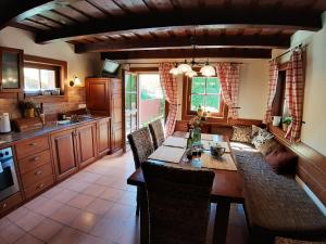 a kitchen with a long wooden table and chairs at Chata DOBROTKA in Liptovský Mikuláš