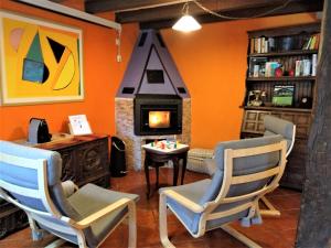 a living room with two chairs and a fireplace at Casa Rural Madera y Sal in Salinas de Añana