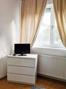 a white dresser with a computer on it in front of a window at Casa File de Poveste in Târgu Jiu