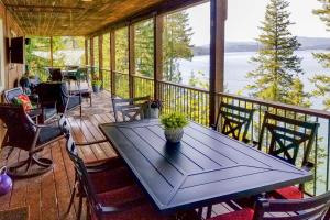 a screened in porch with a table and chairs at Swim, Boat and Explore! South Lake Coeur dAlene Gem in Worley