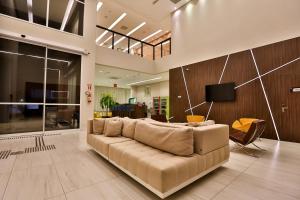 una sala de estar con un sofá grande en una habitación en Summit Suítes Hotel Pindamonhangaba, en Pindamonhangaba