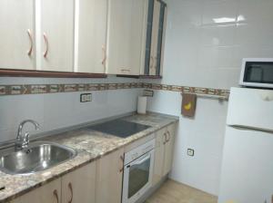 a small kitchen with a sink and a refrigerator at El LEGADO in Andújar