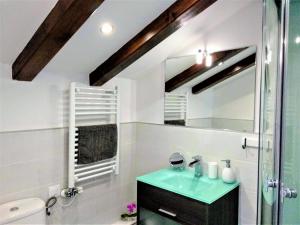 a bathroom with a green sink and a mirror at Casa Rural Madera y Sal in Salinas de Añana +117 photos