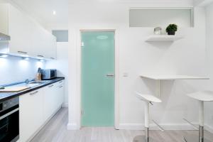 a kitchen with white cabinets and a blue door at GreatStay Lachmannstr. 3 in Berlin