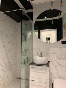 La salle de bains est pourvue d'un lavabo et d'un miroir. dans l'établissement Gdańsk Old Town - Elegant Apartment, à Gdańsk