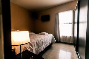 1 dormitorio con cama y ventana en Apartamentos Boulevard I en San Rafael