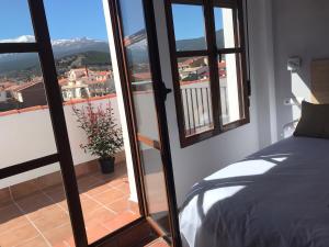 a bedroom with a bed and a view of a balcony at Hotel El Picón de Sierra Nevada in Jerez del Marquesado