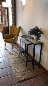 a table and a yellow chair in a room at Hotel El Picón de Sierra Nevada in Jerez del Marquesado