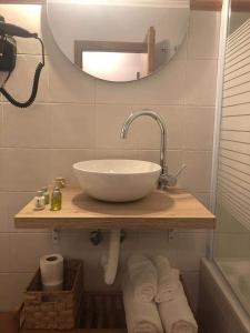 a bathroom with a sink and a mirror and towels at Hotel El Picón de Sierra Nevada in Jerez del Marquesado